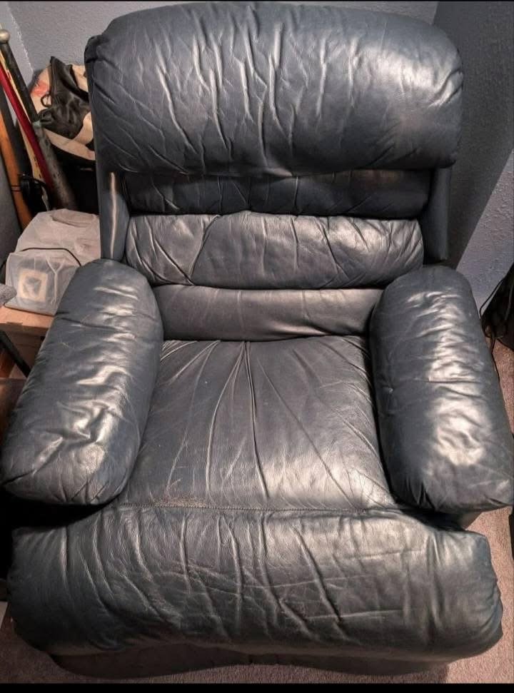 Dull, faded blue leather recliner before professional upholstery cleaning